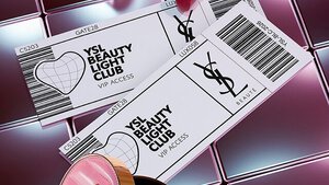 Prodotti di bellezza YSL tra cui una trousse trapuntata, un mascara e due rossetti su sfondo in piastrelle rosa lucide.