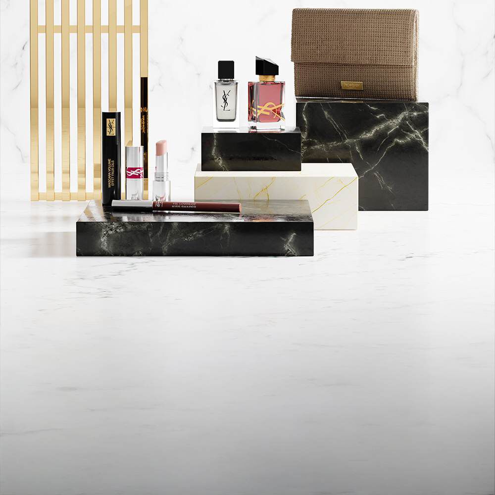 Prodotti di bellezza YSL su piedistalli di marmo di lusso.