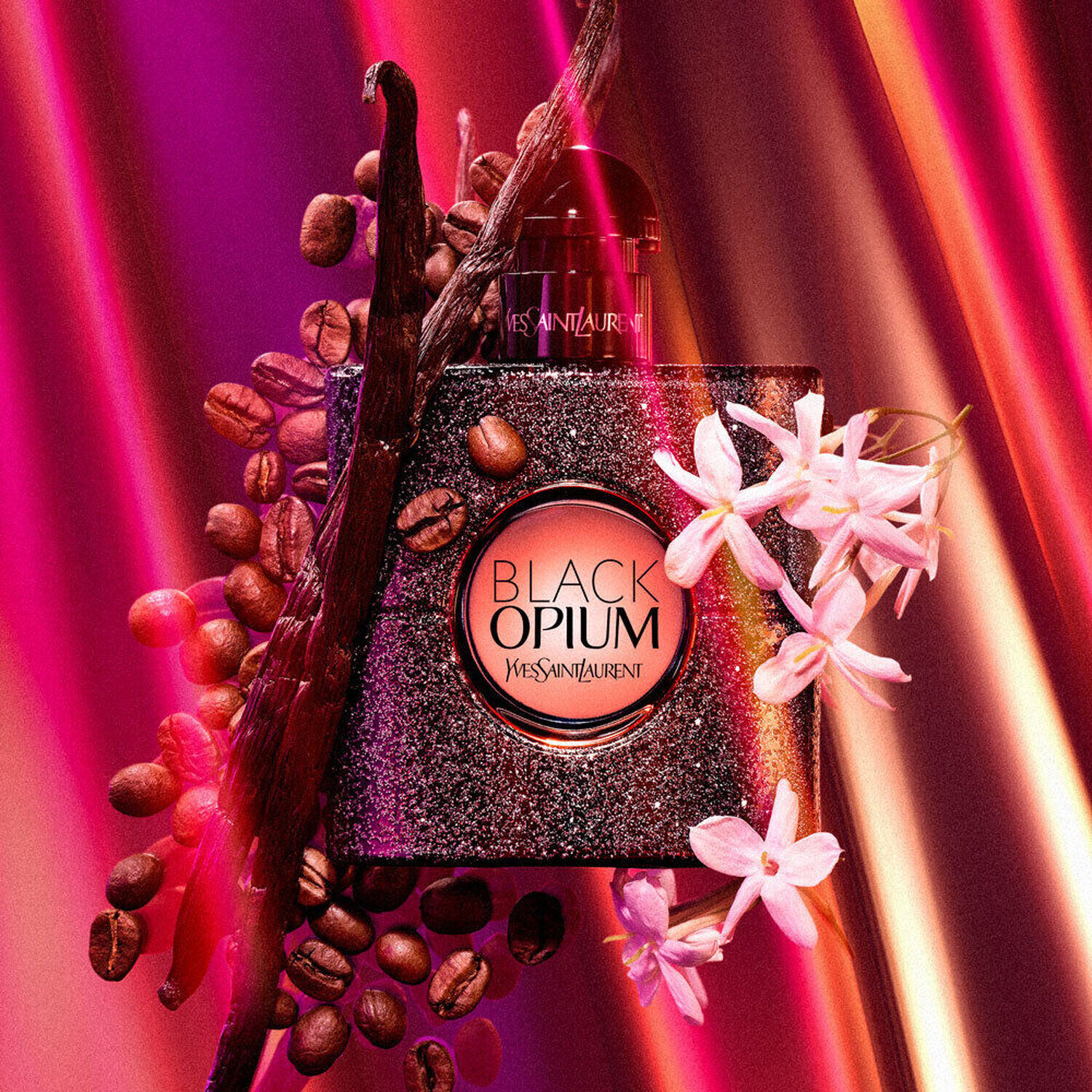 An elegant bottle of Black Opium perfume by Yves Saint Laurent surrounded by coffee beans and white flowers, set against a vibrant, colorful background of pink and purple hues.