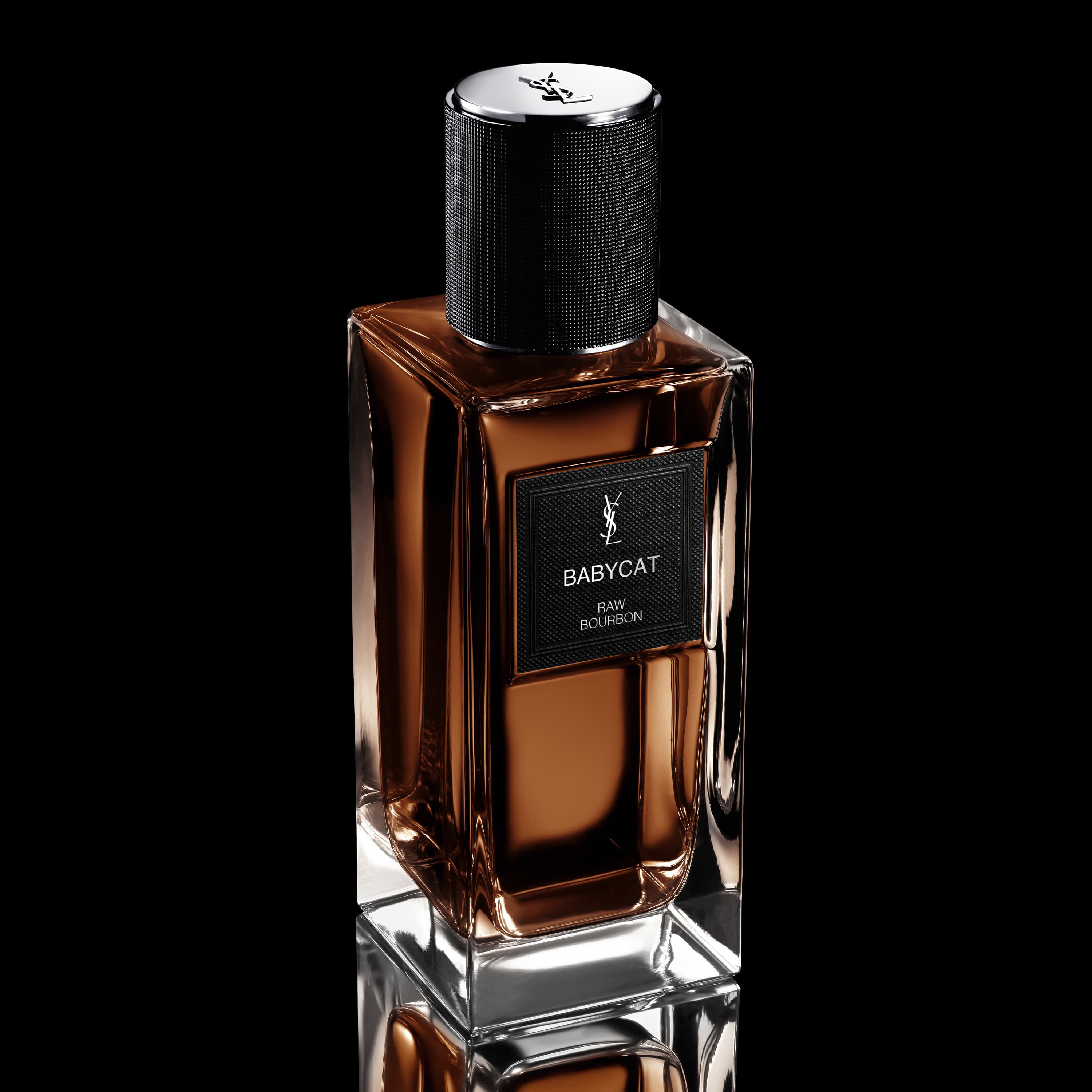 Flacone di profumo YSL Babycat Raw Bourbon con liquido marrone, etichetta nera e tappo nero testurizzato.