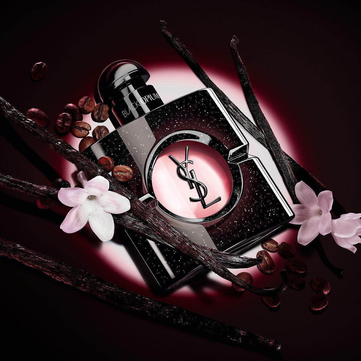 Flacone di Black Opium Eau de Parfum con fiori di gelsomino bianco, baccelli di vaniglia e chicchi di caffe tostati.
