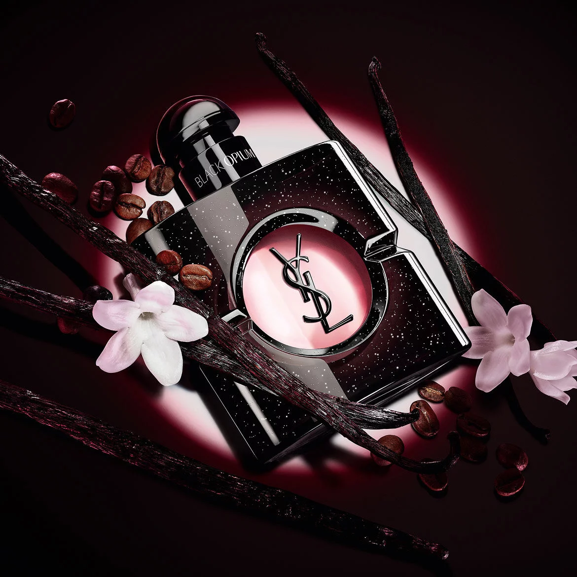 Flacone di Black Opium Eau de Parfum con fiori di gelsomino bianco, baccelli di vaniglia e chicchi di caffe tostati.