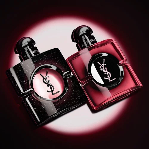 Due flaconi di profumo Black Opium di Yves Saint Laurent illuminati su sfondo scuro.