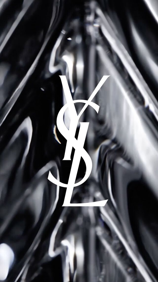 Logo YSL bianco su sfondo di vetro sfaccettato nero.