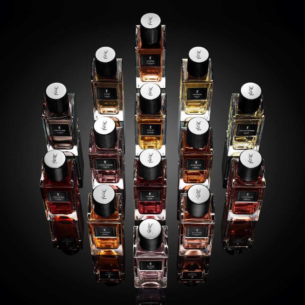 Flaconi di profumo YSL disposti in una composizione geometrica su sfondo nero