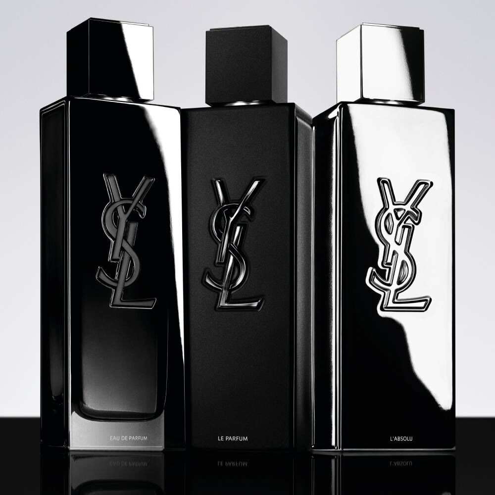 Tre flaconi di profumo YSL neri su sfondo chiaro