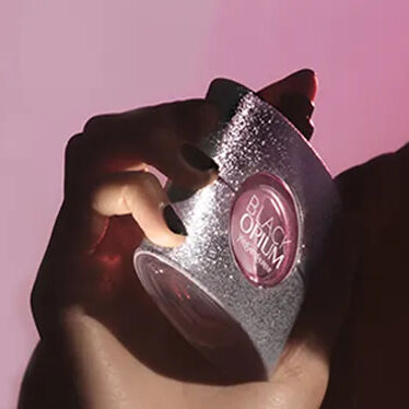Confezione regalo YSL rossa con fiori rosa su sfondo rosso.