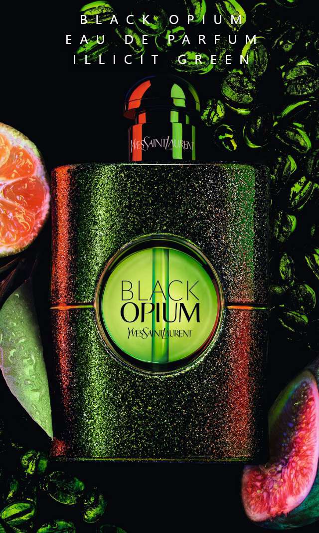 Un flacone di profumo Black Opium di Yves Saint Laurent circondato da agrumi e chicchi di caffe su uno sfondo scuro e verde.
