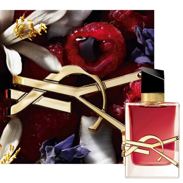 Primo piano del flacone Libre Berry Crush con logo YSL dorato, avvolto da bacche rosse ed elementi floreali.