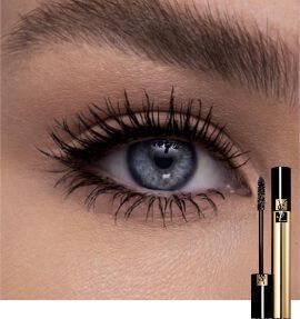 Close-up of a blue eye showcasing long, defined eyelashes next to a tube of mascara.