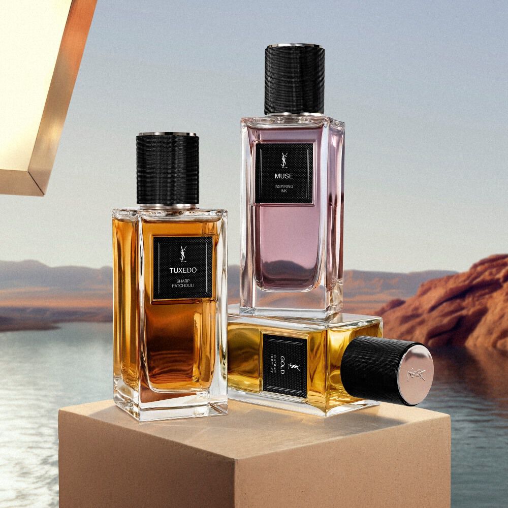 Flaconi YSL Le Vestiaire des Parfums esposti su un piedistallo accanto a un lago nel deserto.