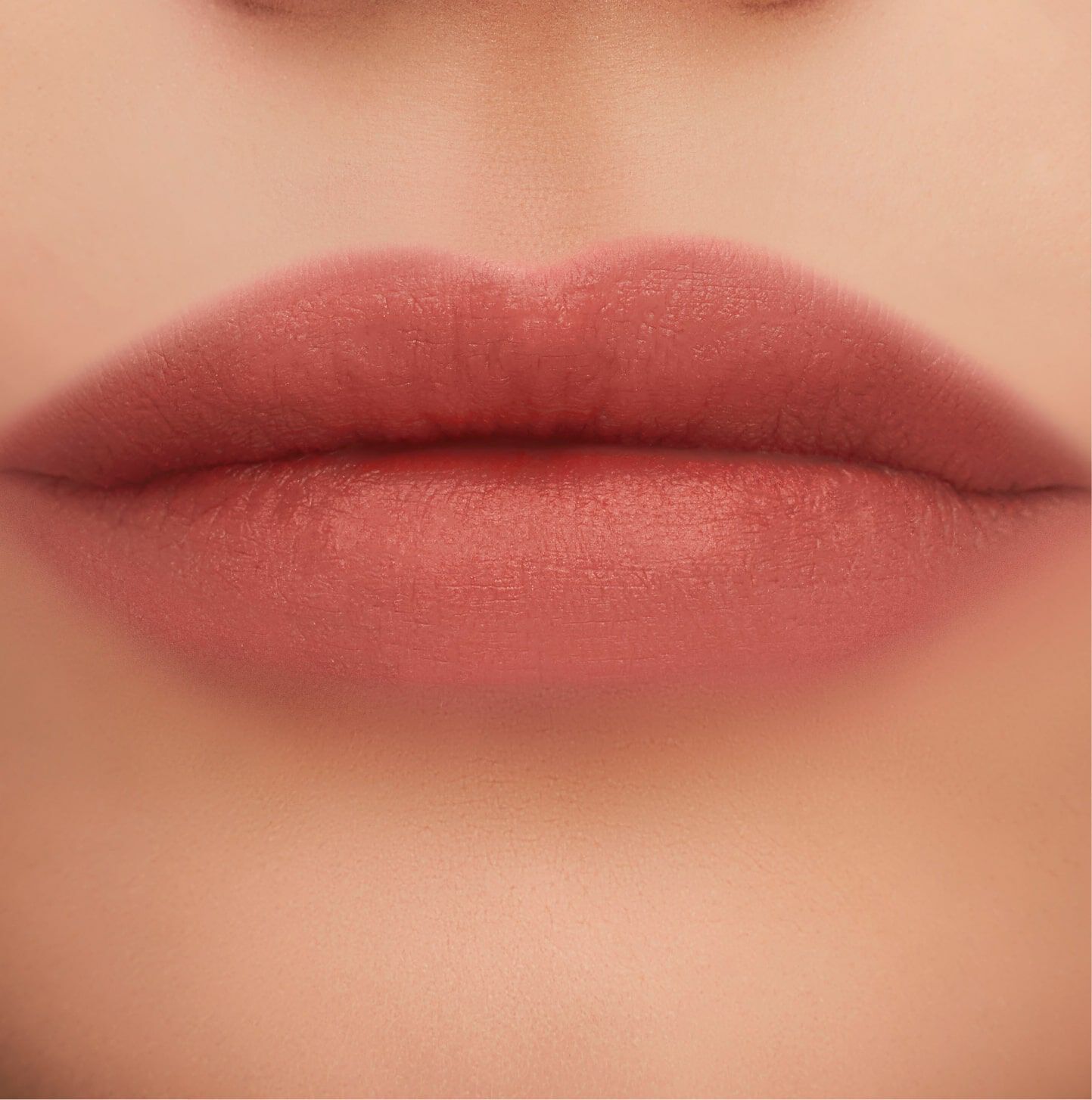 Close-up of well-defined lips with a matte, nude pink lipstick finish.