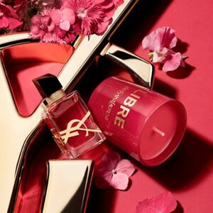 Confezione regalo YSL rossa con fiori rosa su sfondo rosso.
