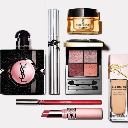 Flat lay di prodotti di bellezza YSL tra cui profumo, trattamento e trucco.