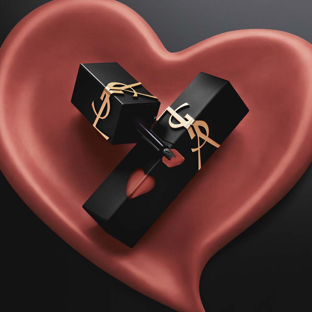 Due modelle audaci in trench nero e giacche di pelle stringono rossetti YSL davanti a un’enorme sfondo a cuore rosa. Labbra lucide, rosso intenso. Labbra morbide, rosa opaco. Un contrasto che sfida. Un gesto che seduce.
