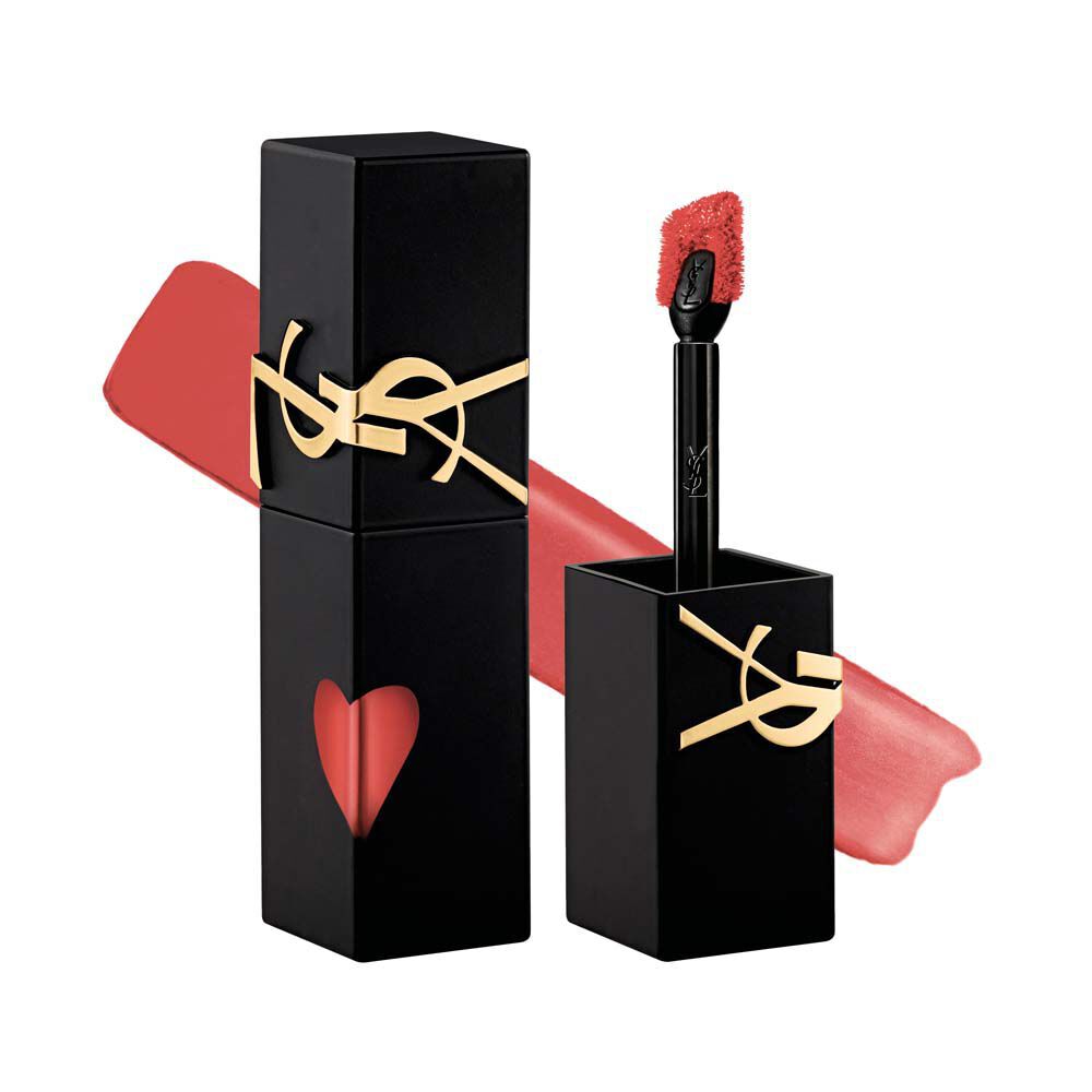Flacone di rossetto YSL nero opaco accanto al suo tappo svitato e al pennello applicatore, esposto davanti a una sfumatura di texture liquida morbido-opaca.