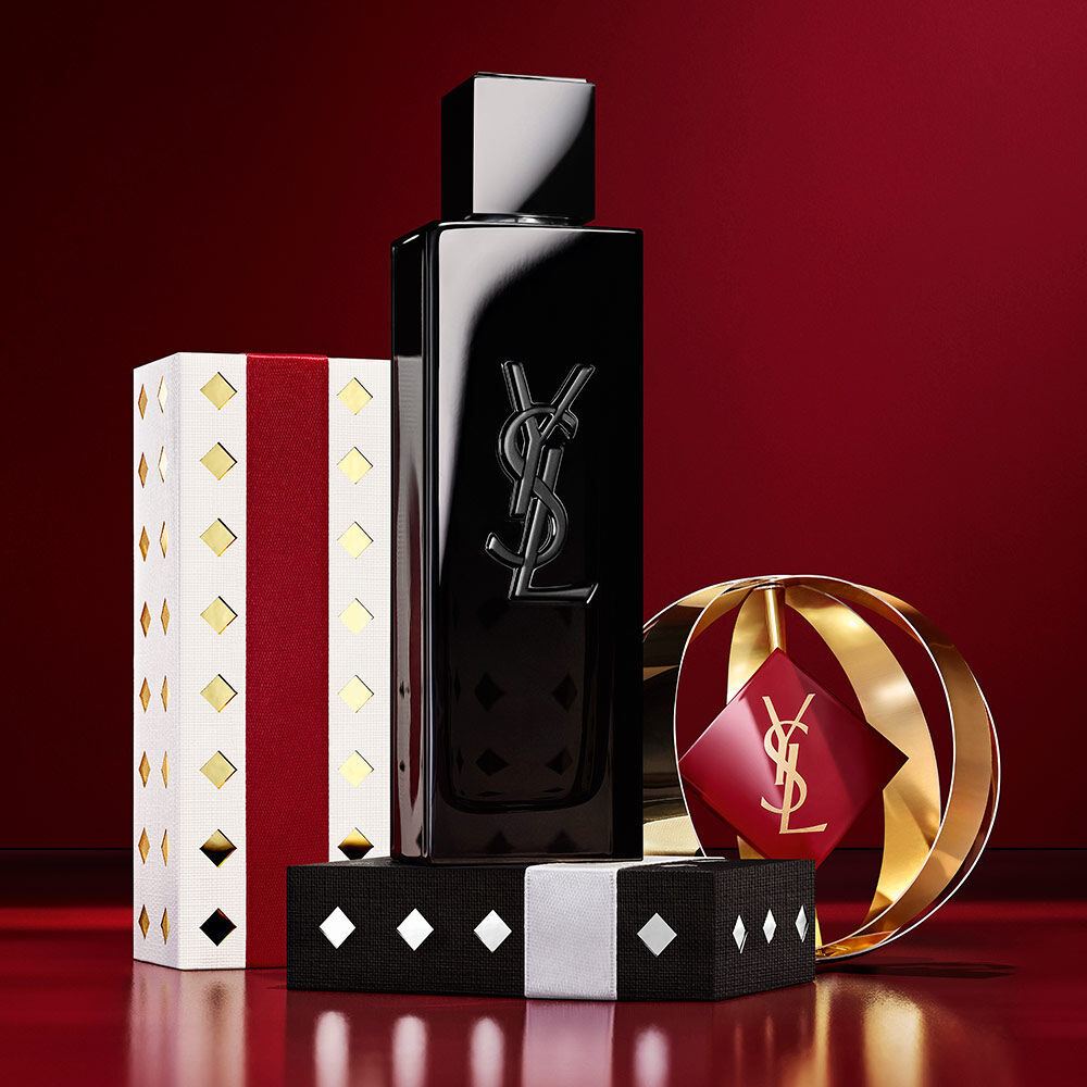 Flacone di MYSLF in mostra con confezioni regalo YSL Holiday in oro e bordeaux.