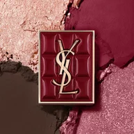 YSL Couture Mini Clutch si staglia su uno sfondo testurizzato di ombretti scintillanti, polvere di #1982 Burgundy Millesime.