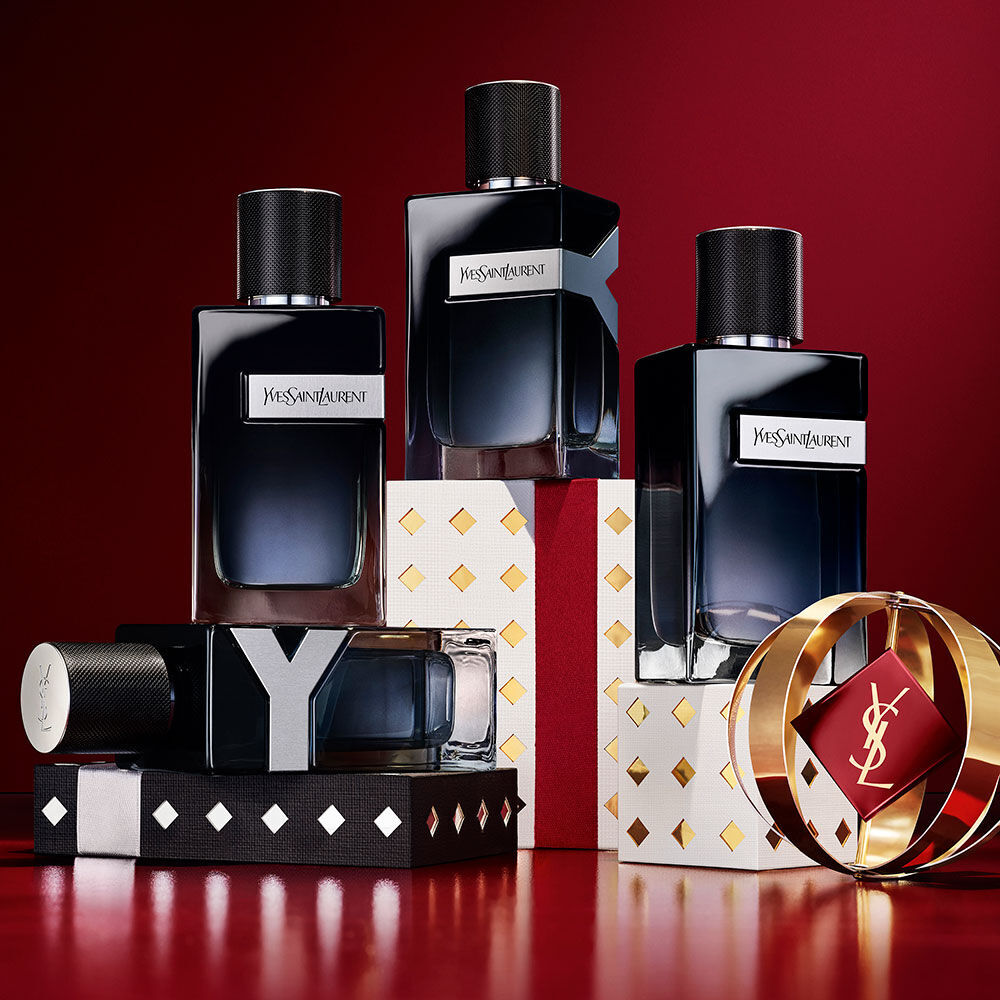 Flaconi di YSL Y Eau de Parfum impilati su confezioni regalo Holiday in nero, bianco e oro.