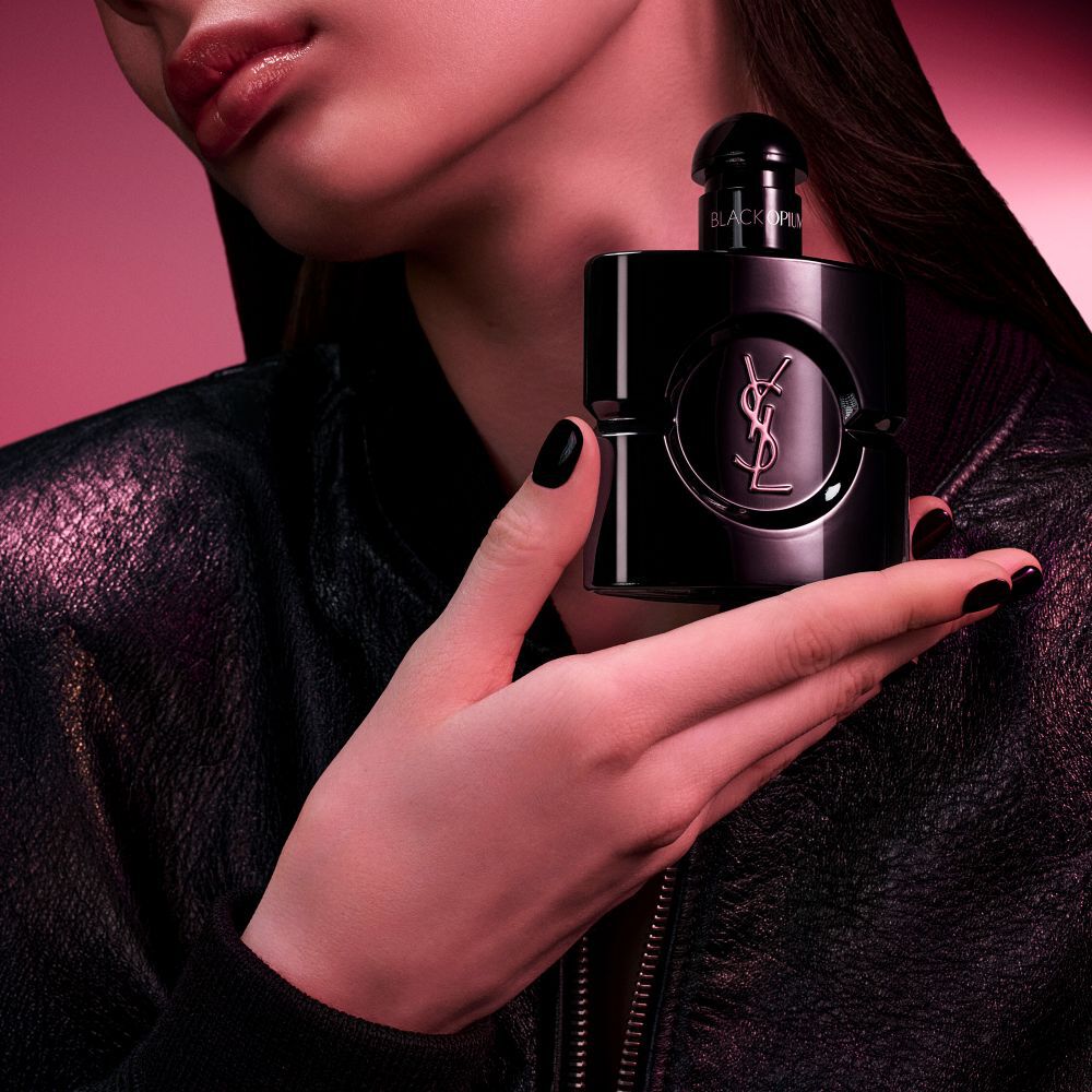 Flacone Black Opium Le Parfum in nero lucido, circondato da baccelli di vaniglia scura e gelsomino bianco con claim.