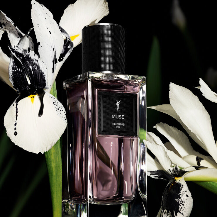Flacone di profumo YSL con fiori bianchi e inchiostro nero.