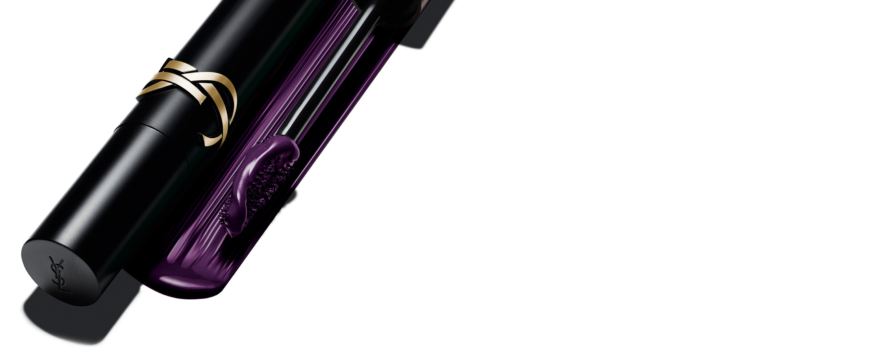 Mascara Lash Clash di Yves Saint Laurent in tonalità prugna, con il pack nero e logo YSL dorato e lo scovolino che mostra la texture viola.