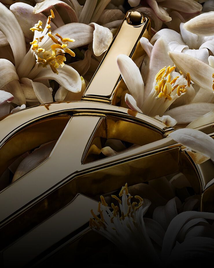 Cassandre YSL dorata con fiori bianchi d'arancio.