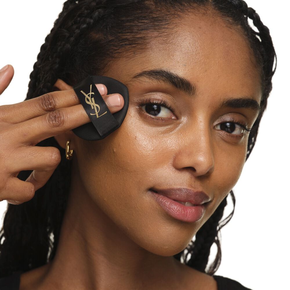 Close-up che mostra come applicare YSL SKIN AFFAIR CUSHION sulla guancia per una copertura uniforme, modulabile e luminosa.