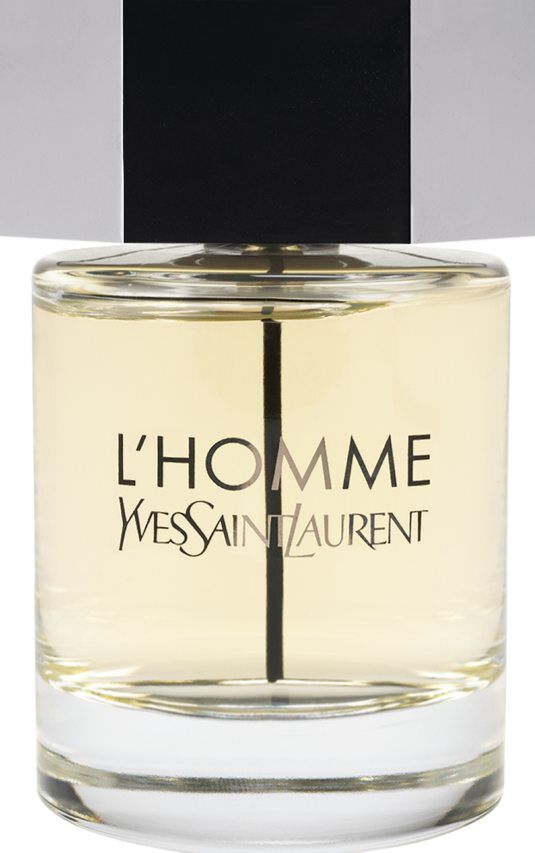 Un flacone del profumo Yves Saint Laurent L'Homme con corpo in vetro trasparente, liquido ambra chiaro e un grande tappo esagonale argentato.