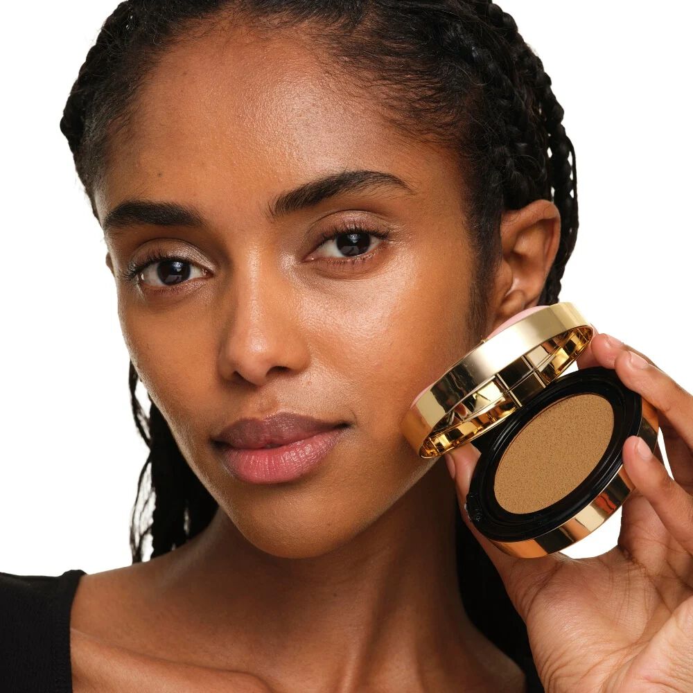 Modella con pelle media che tiene YSL SKIN AFFAIR SOFT GLOW CUSHION. Carnagione radiosa, uniforme e dall’aspetto naturale.