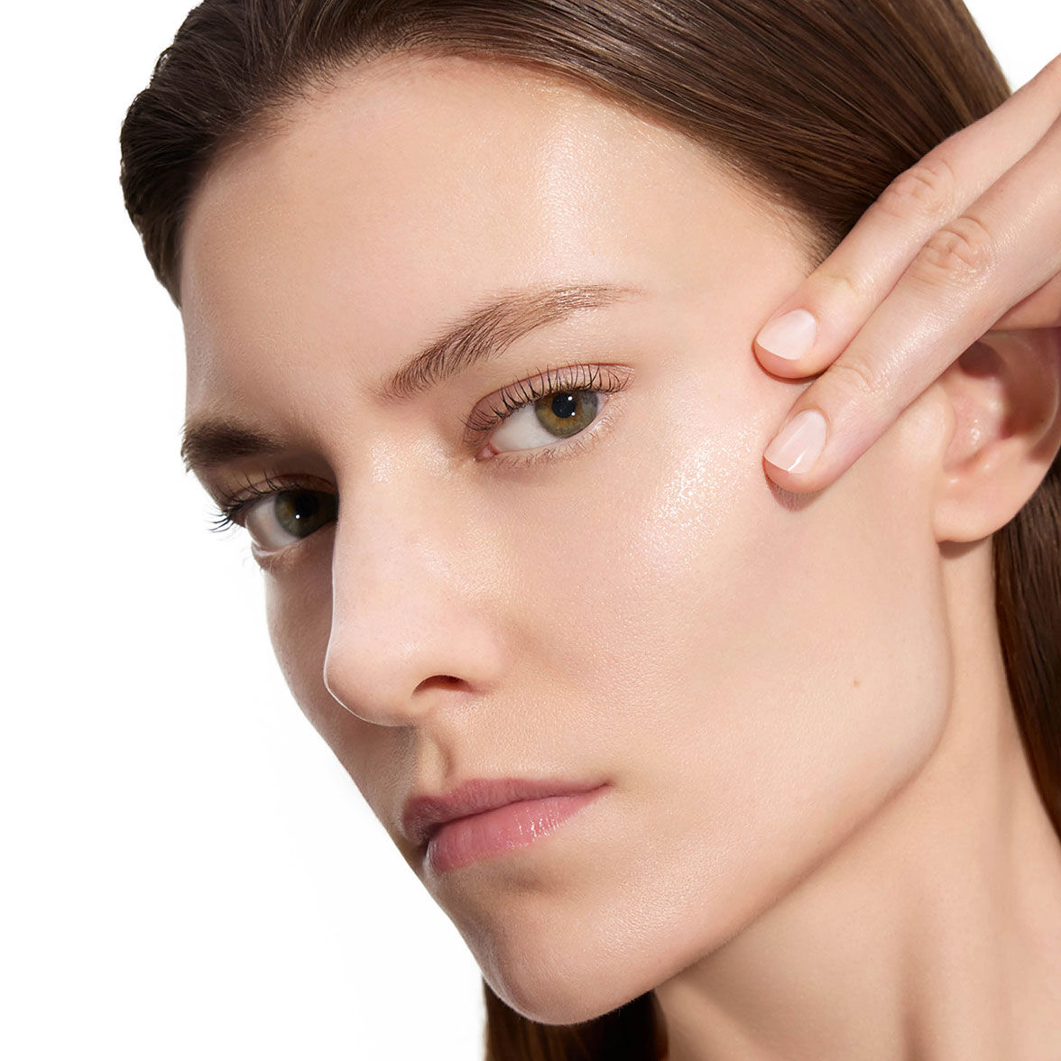 Marije, modella di YSL Beauty, con pelle chiara, si sfiora delicatamente la guancia, mostrando una pelle levigata dopo l'applicazione della lozione.