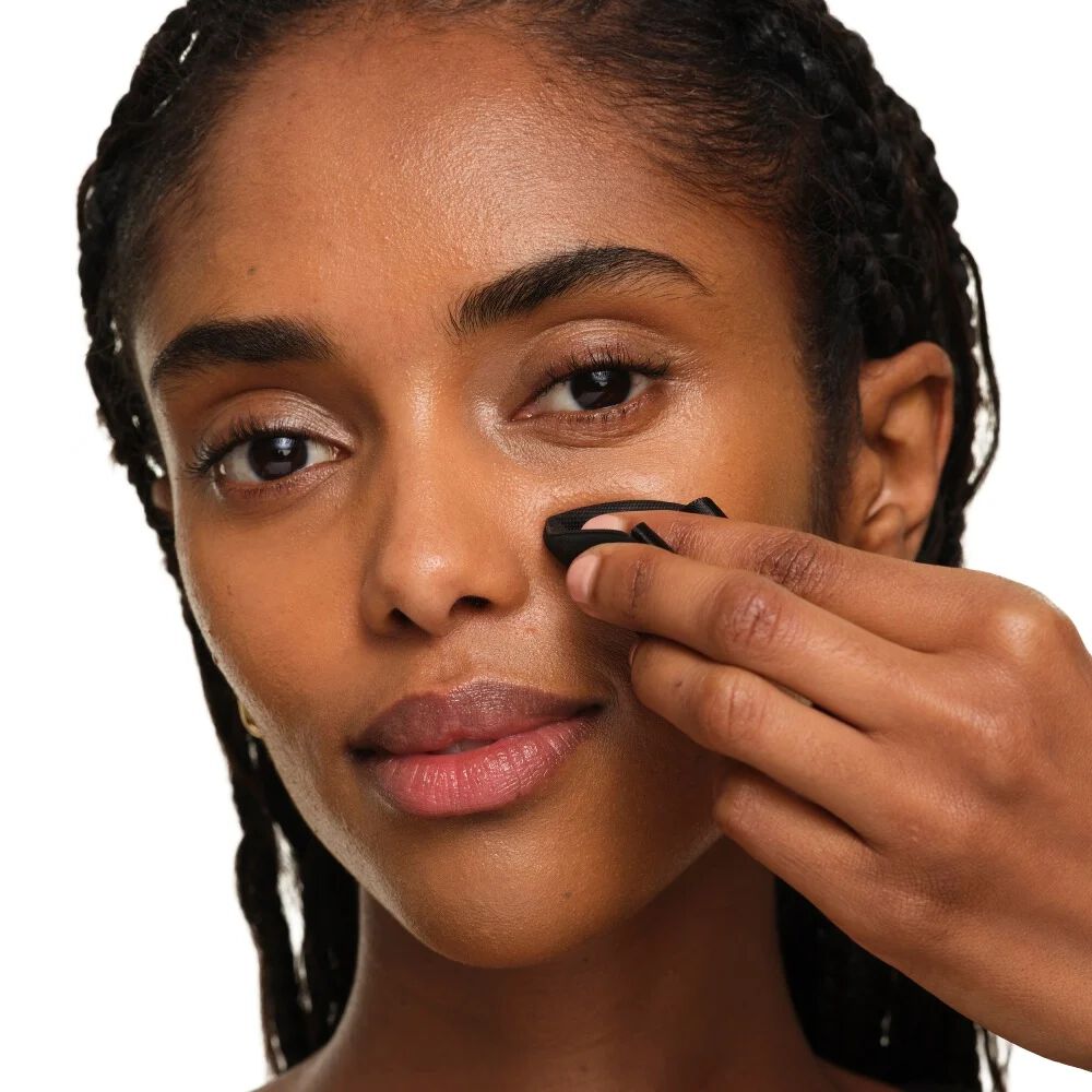 Close-up che mostra come piegare il puff YSL per una precisione mirata e ritocchi intorno a naso e occhi.