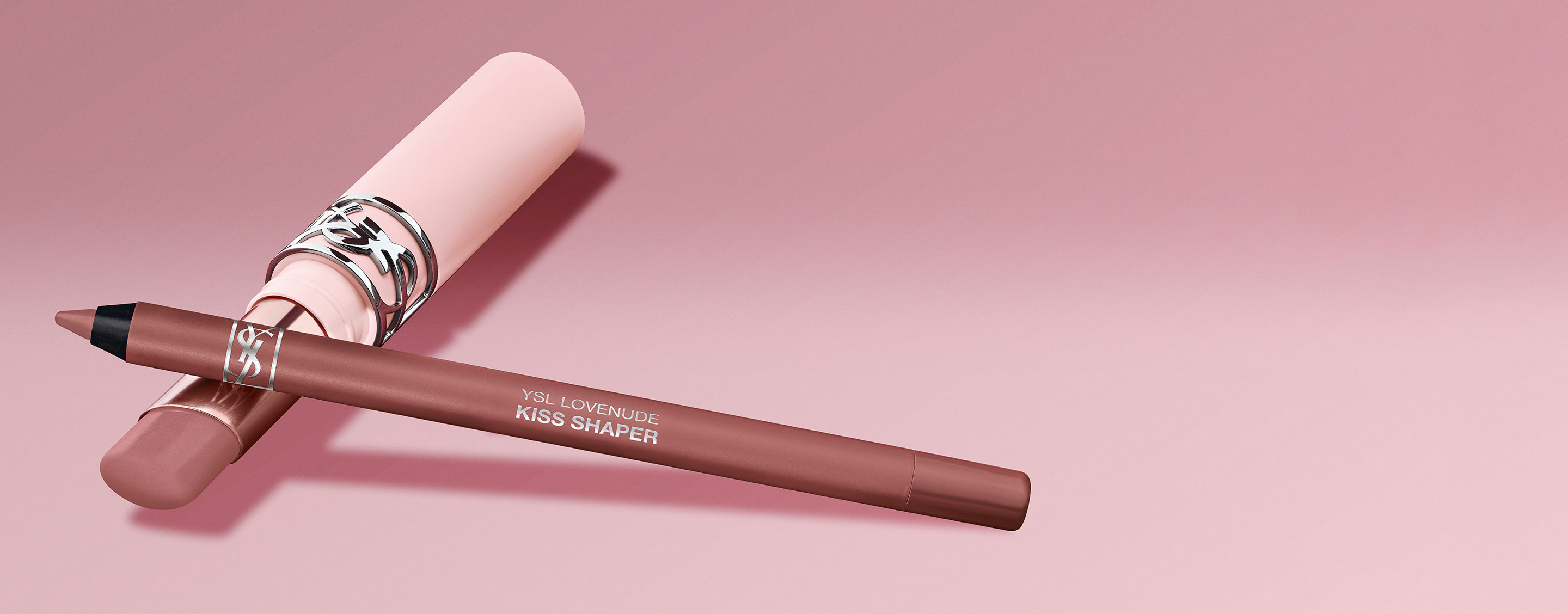Matita labbra YSL Kiss Shaper e prodotto labbra coordinato su sfondo rosa.