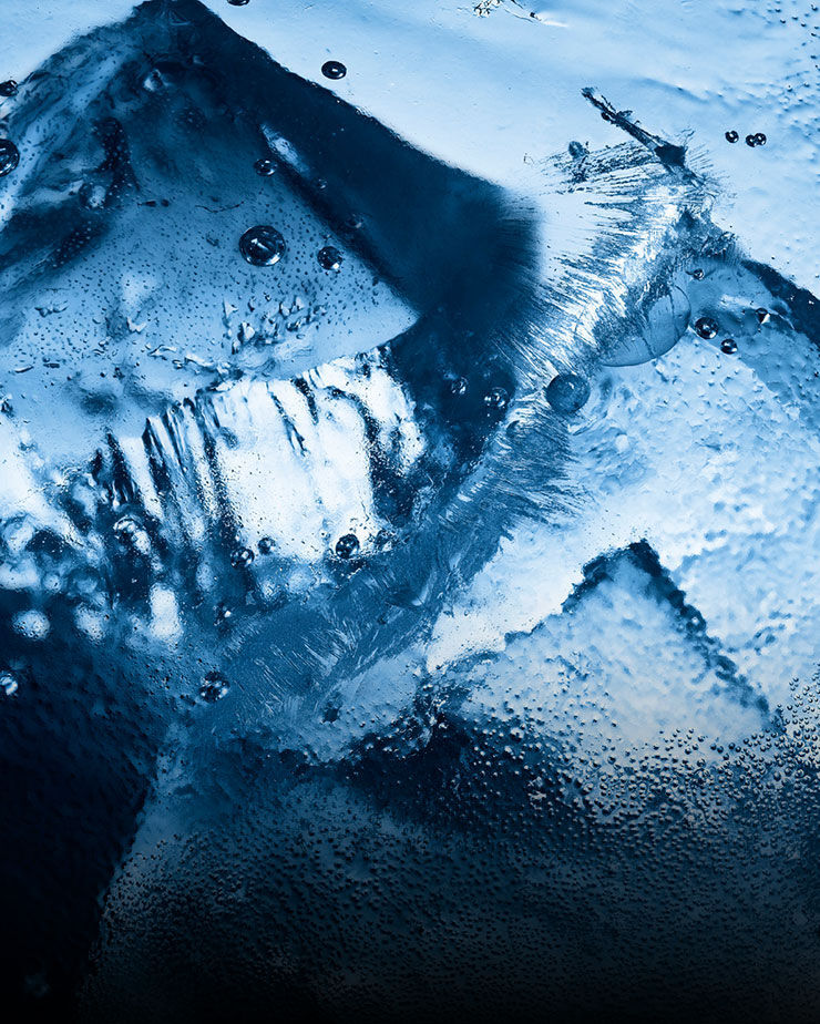 Primo piano di ghiaccio e gocce d'acqua, che evocano l'intensa freschezza glaciale di YSL Y Eau de Toilette Intense Iced Cologne.