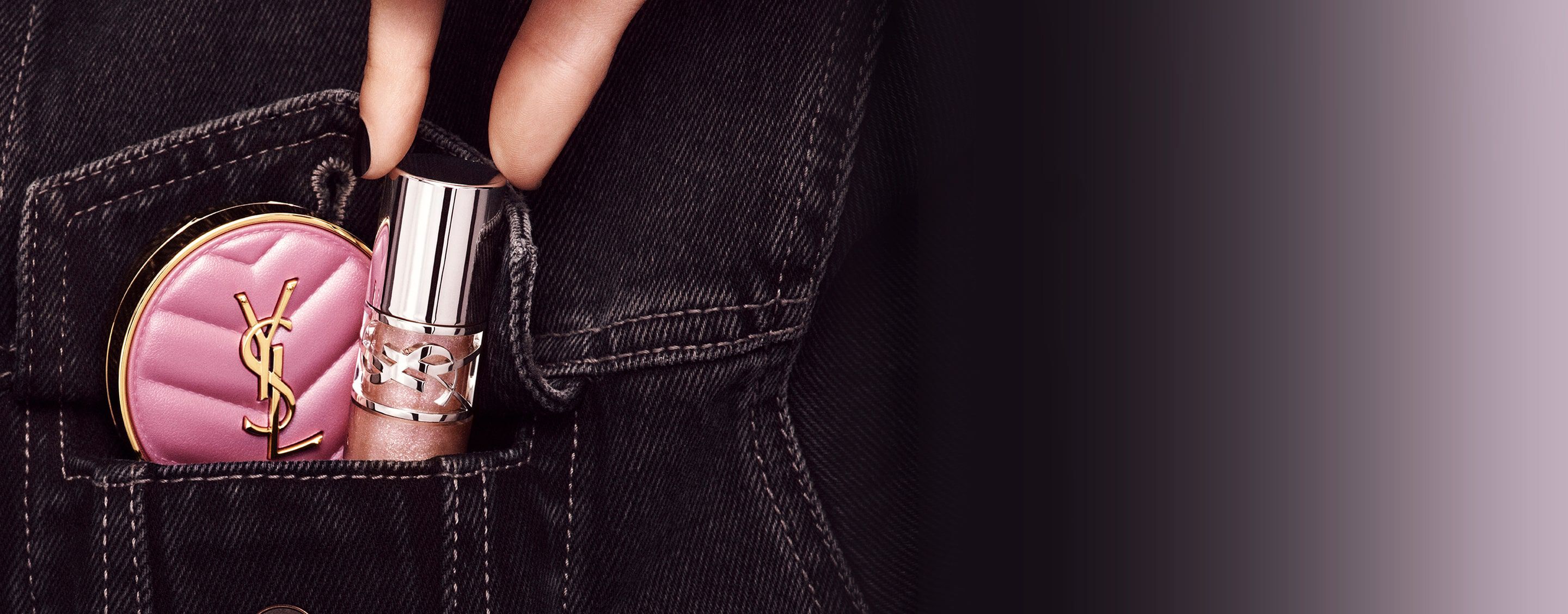 Mano che ripone il lucidalabbra YSL LOVESHINE e il fard rosa Make Me Blush in una tasca di jeans