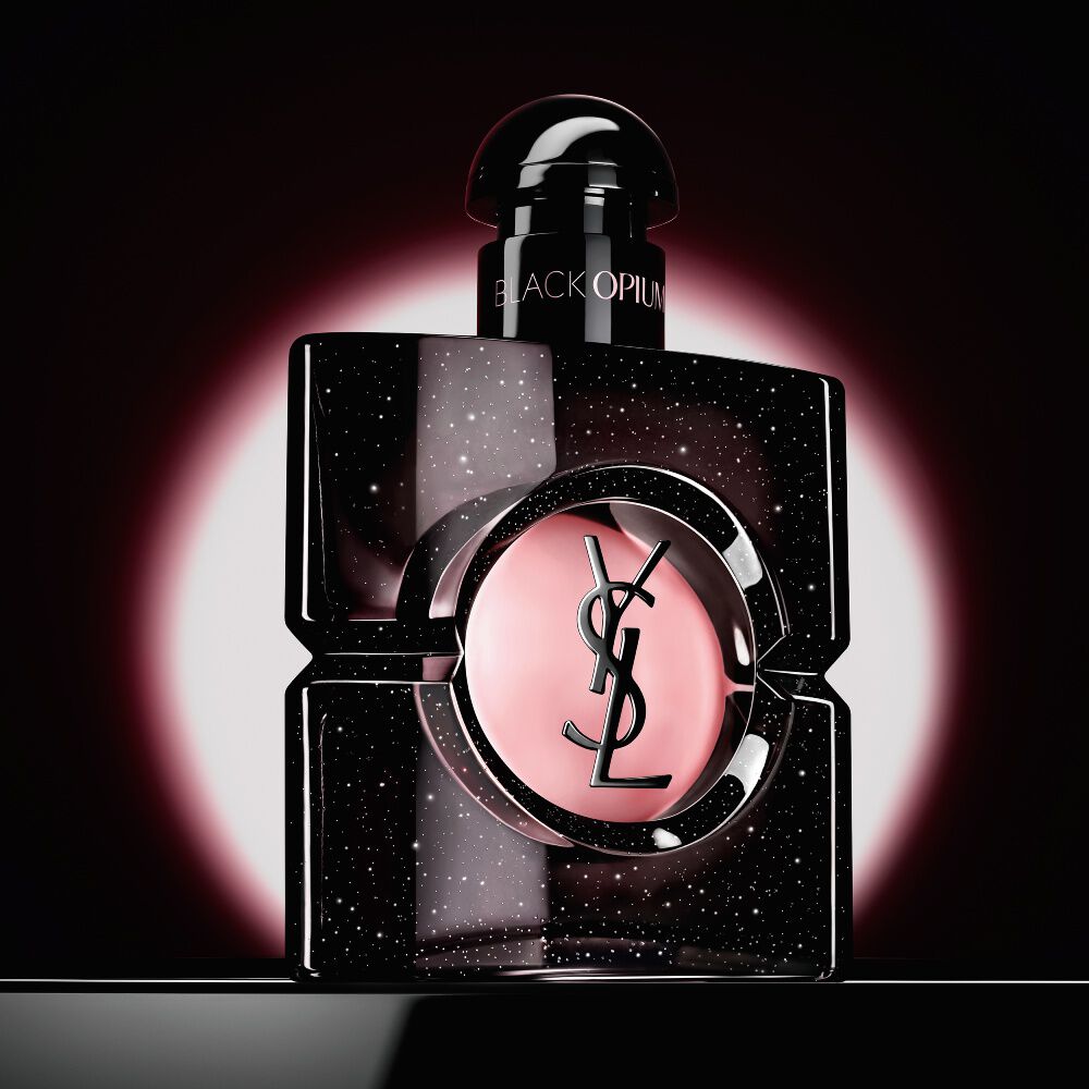 Il flacone Black Opium Eau de Parfum, esaltato da un bagliore circolare rosa su fondo scuro.