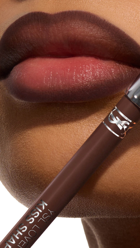 Primo piano verticale di labbra con effetto sfumato marrone e matita labbra YSL Kiss Shaper coordinata.