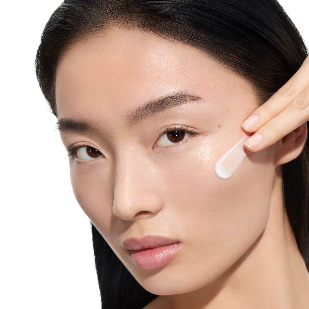 Wen, modella di YSL Beauty con pelle chiara, applica la crema Pure Shots Youth Reload di YSL Beauty sulla guancia.