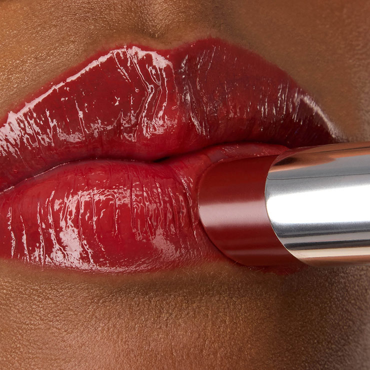 Primo piano del rossetto YSL LOVESHINE nella tonalità Berry Crush 219, applicato sulle labbra rosse, vibranti e lucenti della modella Zahara.