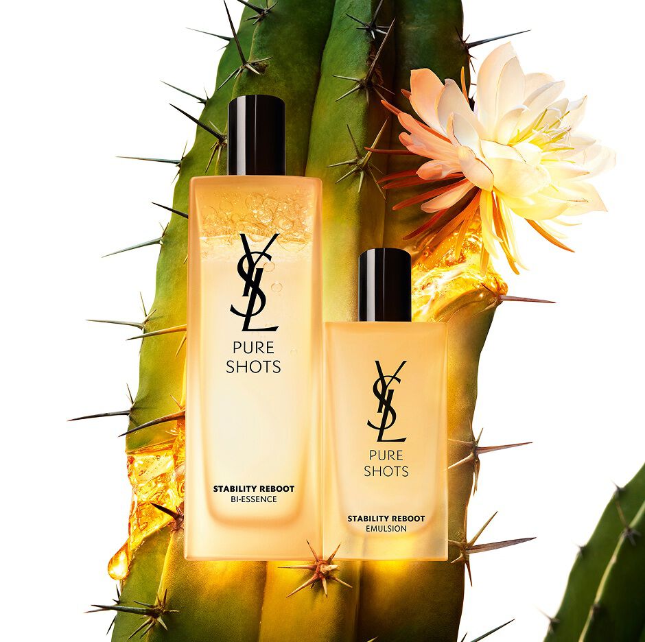 Prodotti YSL Pure Shots Stability Reboot Bi-Essence e Stability Reboot Emulsion davanti a un cactus moonlight in fiore