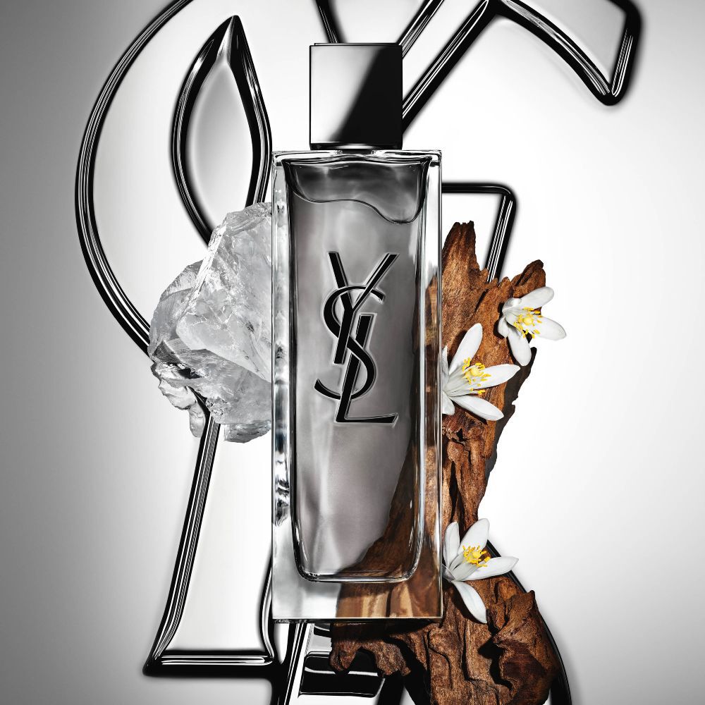 Il flacone di MYSLF Eau de Toilette Intense di YSL Beauty, circondato da fiore d’arancio, legni e muschi bianchi.