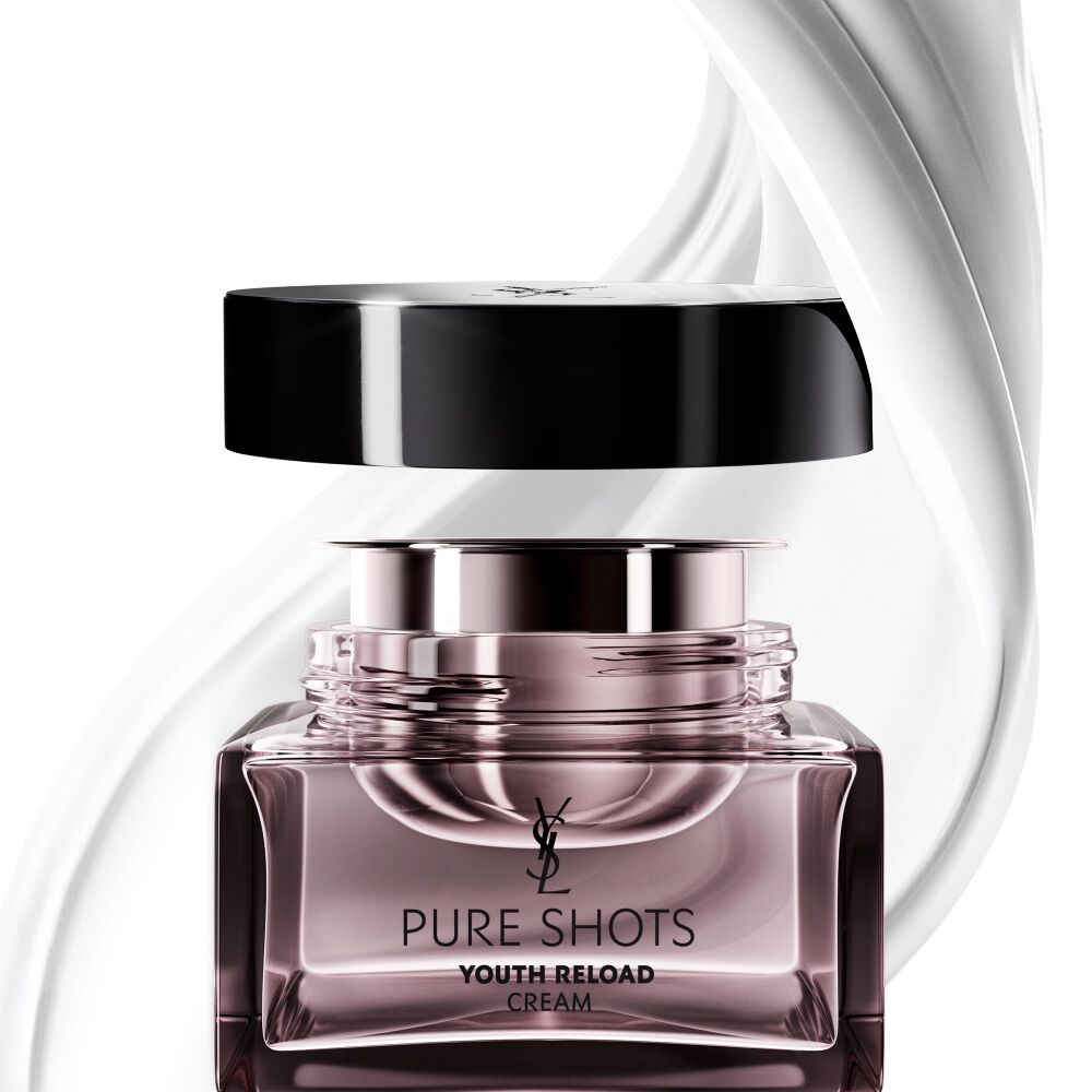 Vaso della crema Pure Shots Youth Reload di YSL Beauty e la sua ricarica sostenibile, circondati da un dinamico vortice della sua texture lussuosa.