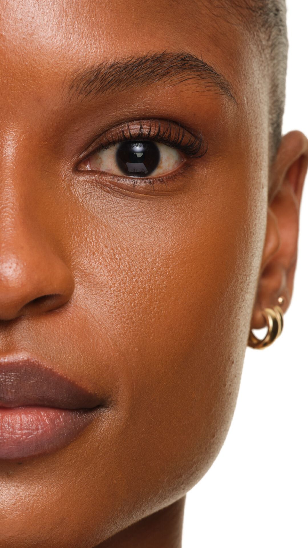 Finish radioso di YSL SKIN AFFAIR FOUNDATION su pelle profonda. Zoom estremo che mostra una texture liscia, uniforme e luminosa.