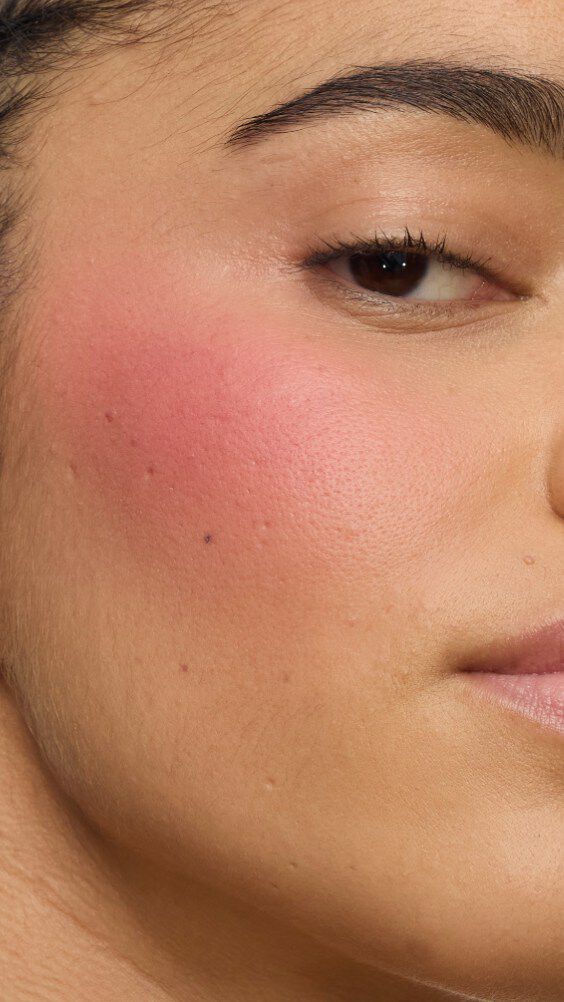 Primo piano del viso di una modella con il look Make Me Blush: Cipria n. 54 Berry Bang stratificata con la Crema n. 44 Nude Lavallière per un tocco di rosa vibrante e personalizzato.