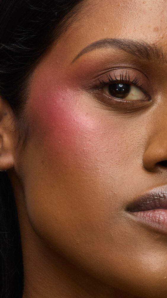 Primo piano del viso di una modella con il look Make Me Blush: Cipria n. 66 Fuchsia Fizz stratificata con la Crema n. 86 Raspberry Glaze per un finish vibrante e succoso.